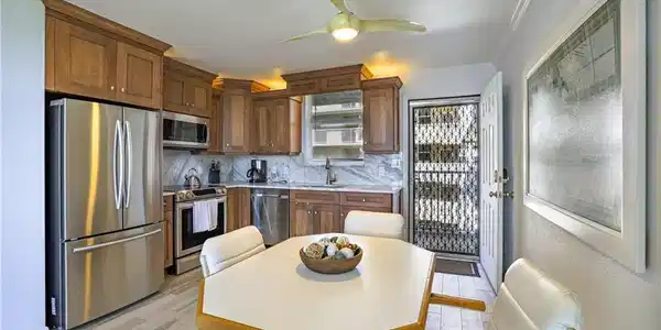 Image 2: Kitchen featuring stainless steel appliances, a ceiling fan, tasteful backsplash, and light wood-style flooring