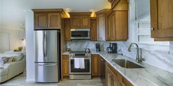 Image 3: Kitchen featuring stainless steel appliances, light stone countertops, wood finish cabinetry, and ceiling fan
