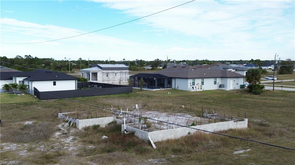 Image 1: Back of house with a residential view and a vegetable garden