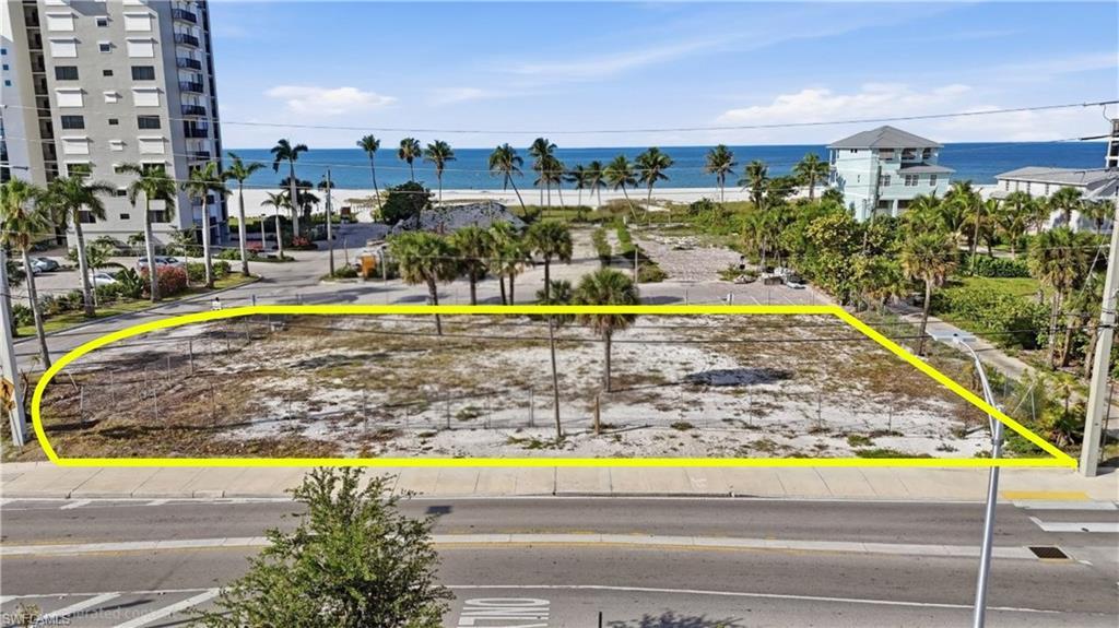 Image 2: Expansive cleared lot featuring partial perimeter fencing - Virtually Edited Image