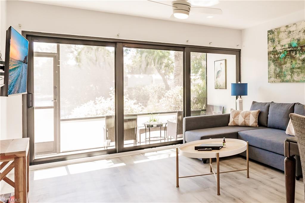 Image 2: Living area with light wood-type flooring and a ceiling fan