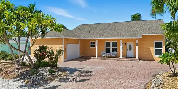 Image 2: View of front of property with pavered driveway, an attached garage, and covered porch- Virtually Edited Image