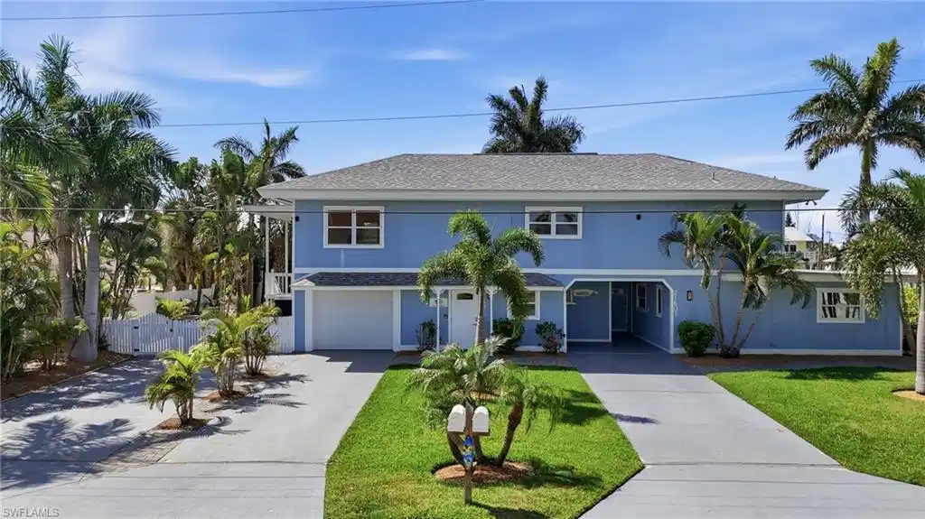 Image 1: Two-story residence featuring a blue exterior, a gray roof, and white window frames - Virtually Edited Image