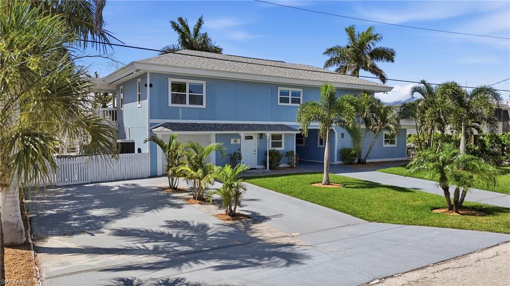 Image 2: Two-story residential structure with blue siding, white trim, and a shingle roof - Virtually Edited Image