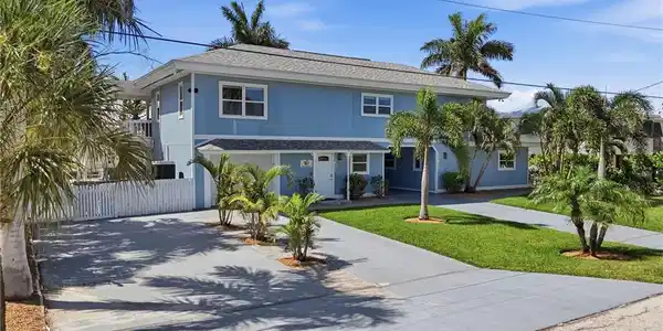Image 2: Two-story residential structure with blue siding, white trim, and a shingle roof - Virtually Edited Image