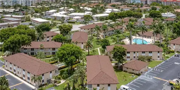 Image 2: Aerial perspective showcasing multiple low-rise buildings with complementary brown tile roofs and light-colored facades