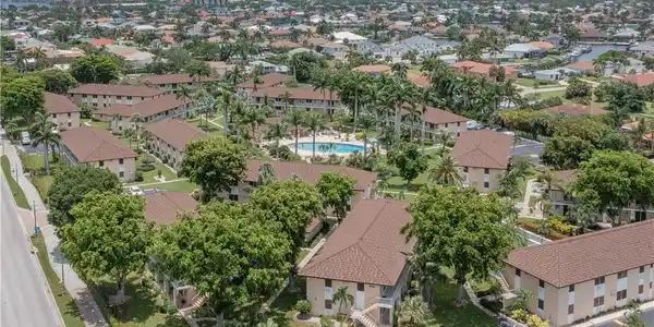 Image 3: Aerial perspective showcasing a community of residential buildings with matching brown shingle roofs