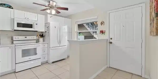 Image 4: Kitchen featuring white cabinetry, white appliances, a ceiling fan, and tile flooring
