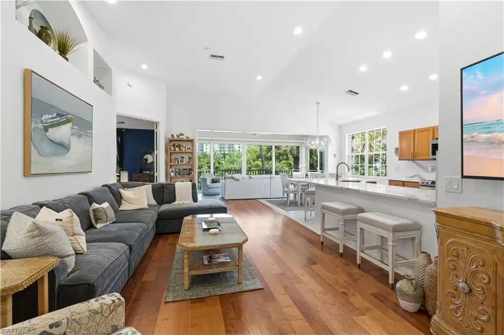 Image 1: Large, open great room room opens to the glass enclosed lanai overlooking the lake.