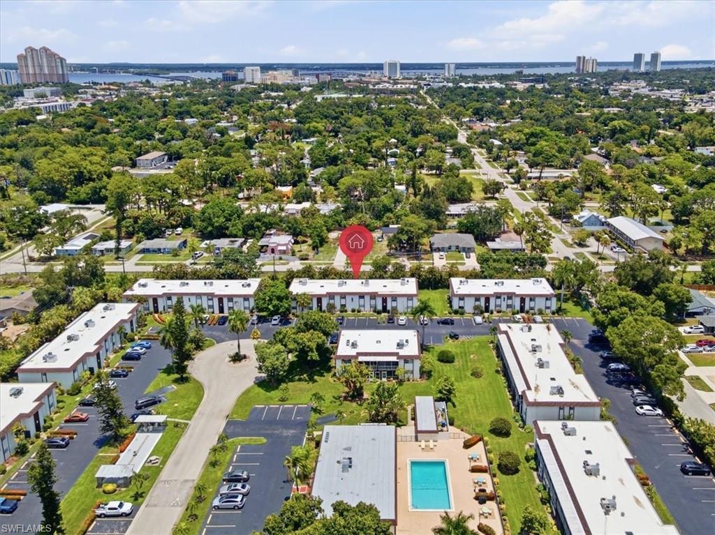 Image 3: Aerial perspective showcasing the multi-building property layout, central swimming pool, multiple parking areas, and mature landscaping