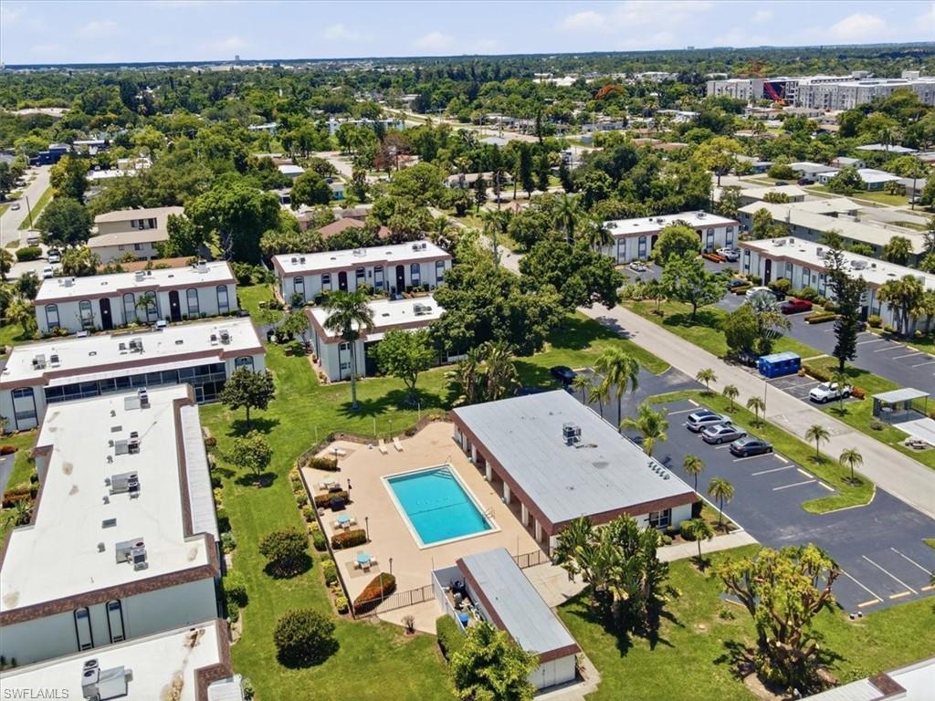 Image 4: Community pool featuring a surrounding paved deck with lounge chairs and shade umbrellas