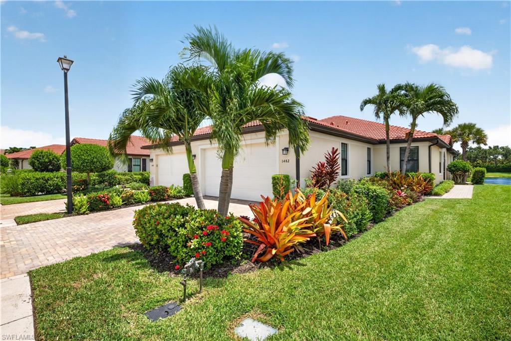 Image 1: Beautiful landscaped yard, sidewalks and a lake behind the home