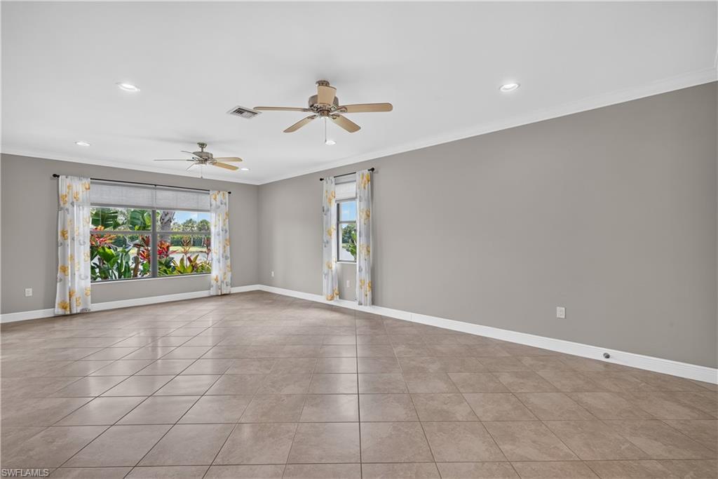 Image 4: Living room with water views, upgraded tile floors, crown molding and 5 1/4" baseboards.