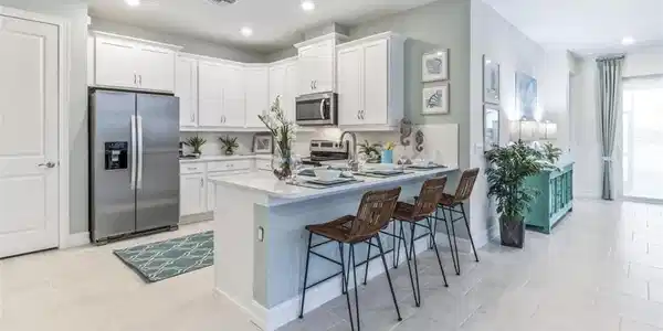 Image 3: Gourmet kitchen with white cabinetry and stainless steel appliances