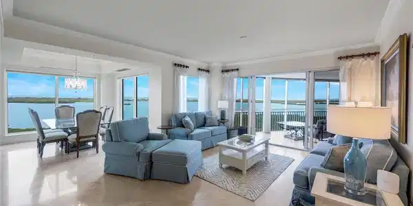 Image 2: The spacious living and dining area of the home feature Floor-to-ceiling windows offering breathtaking views.  Beautiful marble flooring runs throughout the main living areas of the home.
