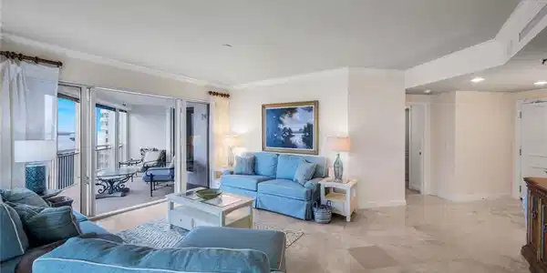 Image 4: The living room opens to a spacious lanai, the perfect spot for enjoying sunsets over the Gulf.