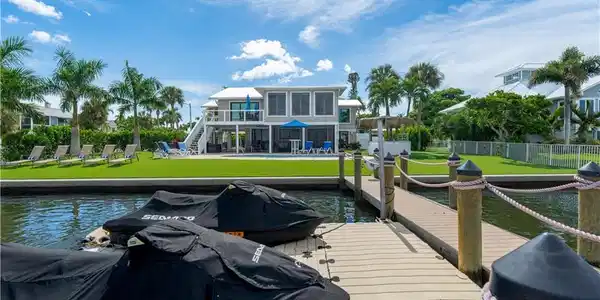 Image 3: Dock featuring stairs, a water view, a patio area, and a balcony - Virtually Edited Image