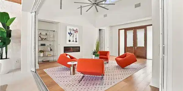 Image 4: Dramatic pocketing doors dissolve the boundaries between the living room and expansive covered lanai