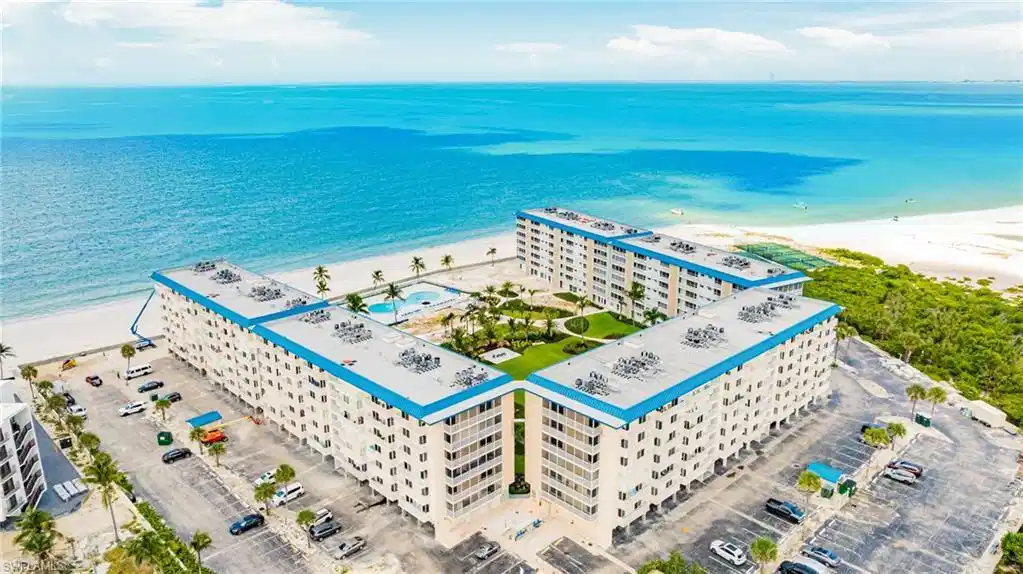 Image 1: Aerial view of expansive coastline and apartment complex / building