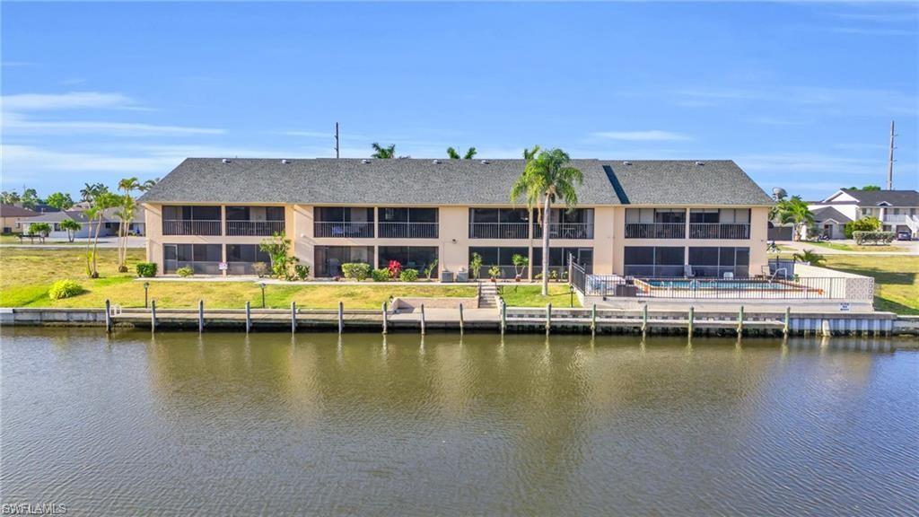 Image 2: Back of property featuring a water view and a shingled roof
