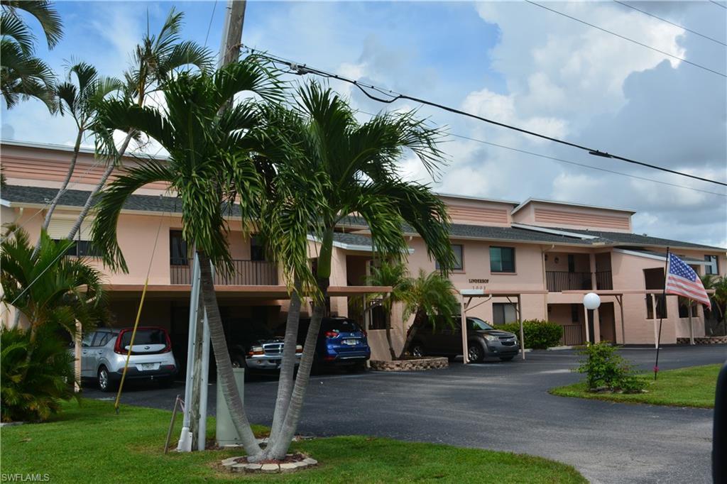 Image 3: View of building exterior with covered parking