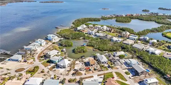 Image 3: Aerial view of property and surrounding area featuring nearby suburban area and a nearby body of water