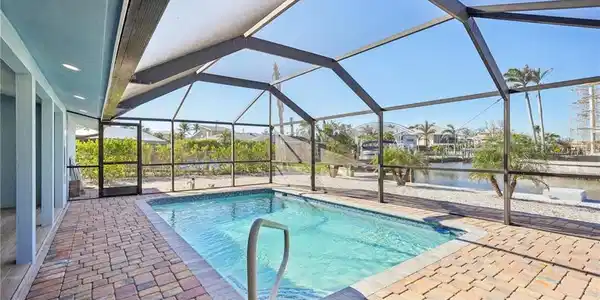 Image 4: Outdoor pool featuring a sunroom, a patio area, a lanai, and a water view