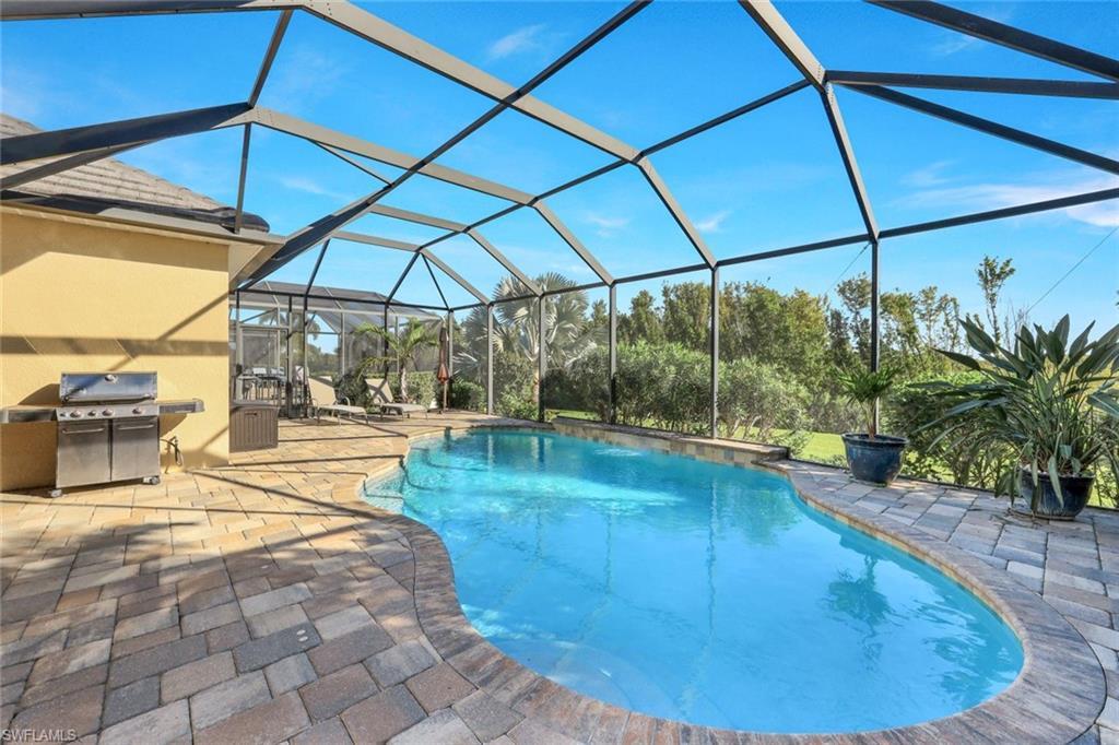 Image 2: Outdoor pool with a lanai, a sunroom, grilling area, and a patio area