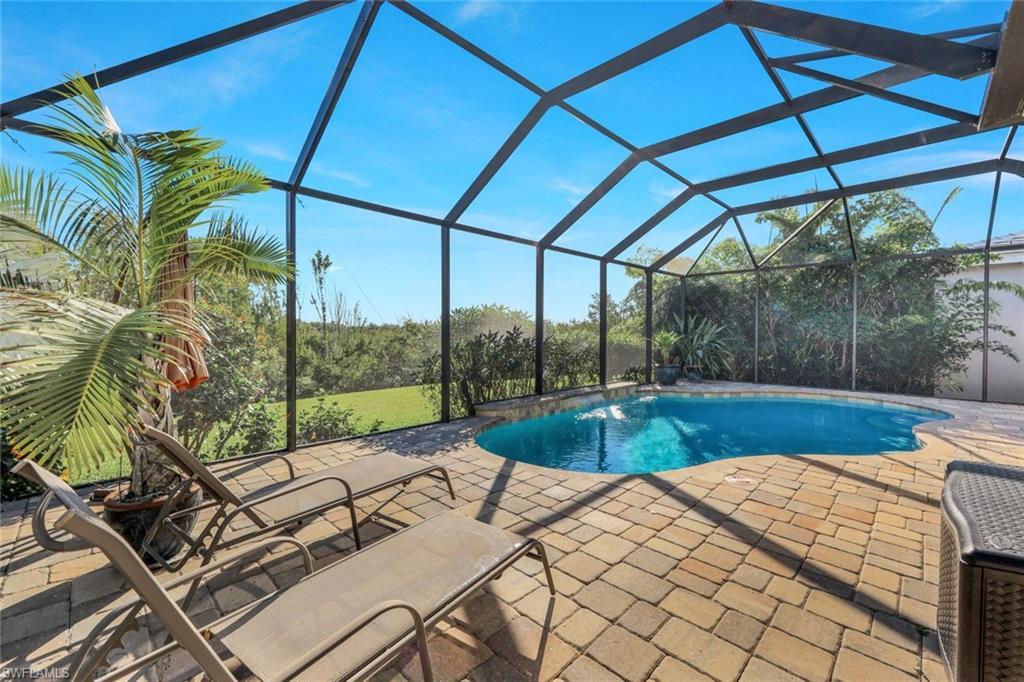 Image 3: Outdoor pool featuring a lanai, a sunroom, and a patio area