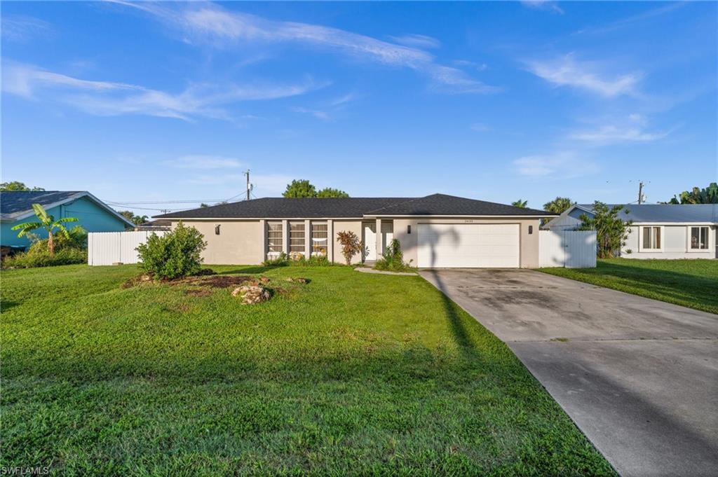 Image 2: Ranch-style home with concrete driveway, stucco siding, and an attached garage