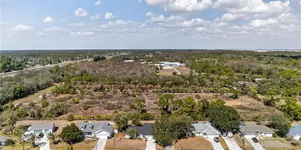 Image 4: Aerial perspective of suburban area featuring a forest