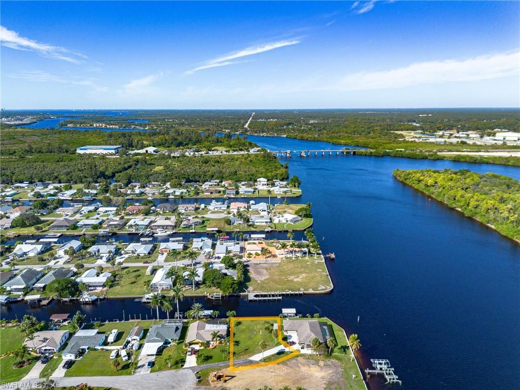 Image 4: Aerial overview of property's location featuring a large body of water and property parcel outlined