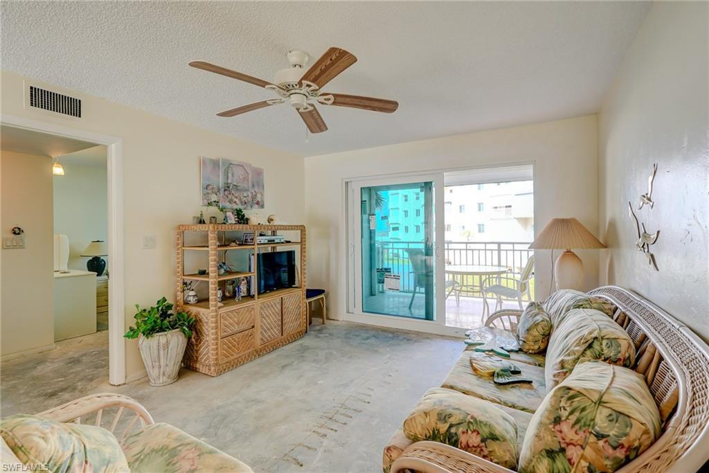 Image 3: Living room with ceiling fan and a textured ceiling