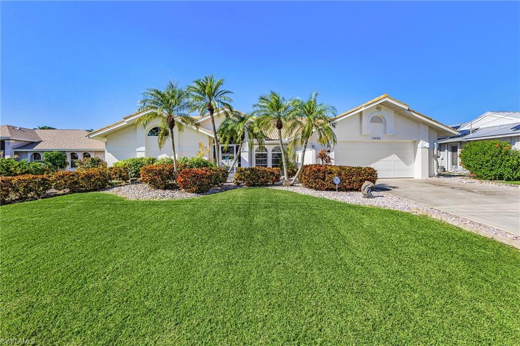 Image 1: Ranch-style house with a front yard, stucco siding, concrete driveway, and a garage