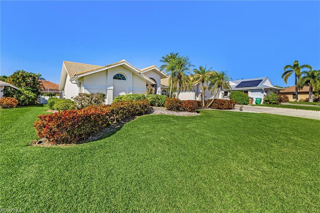 Image 2: Ranch-style house with a front lawn and stucco siding