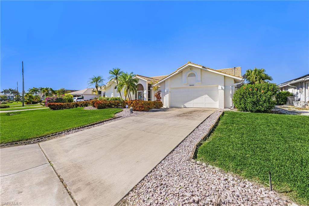 Image 3: Ranch-style house featuring stucco siding, a front lawn, concrete driveway, and an attached oversized two car garage