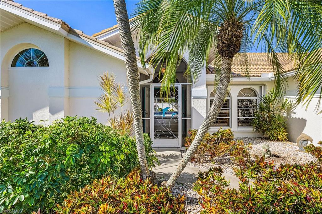 Image 4: View of exterior entry with stucco siding, screened front entry to catch the river breezes