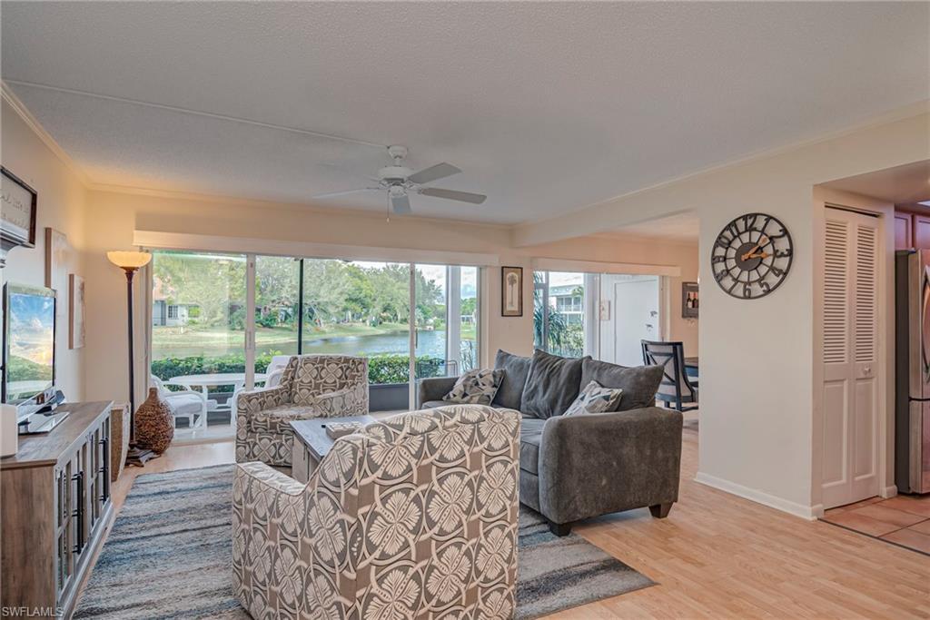 Image 4: Living area with a water view, light wood-type flooring, a ceiling fan, and ornamental molding