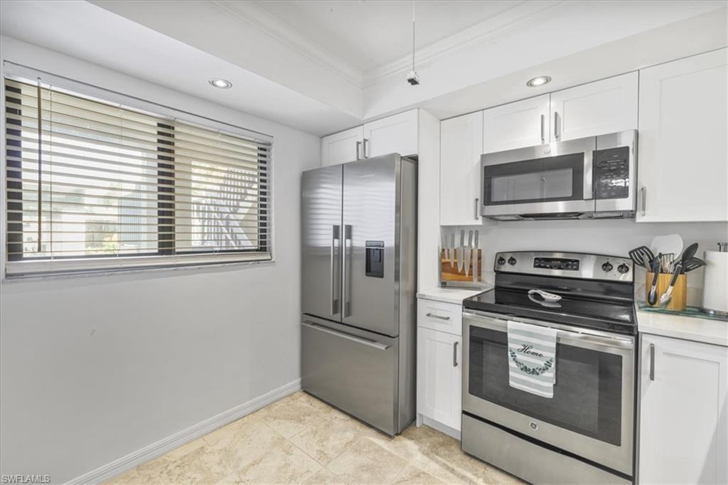 Image 2: Kitchen with appliances with stainless steel finishes, white cabinetry, crown molding, and recessed lighting