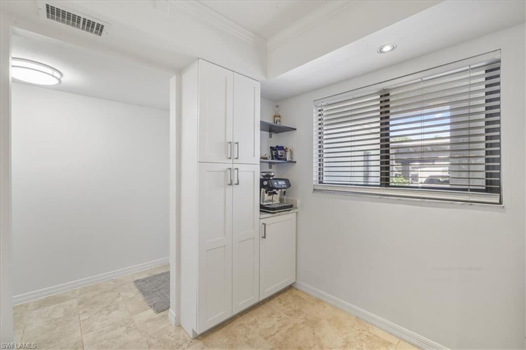 Image 4: Kitchen featuring open shelves, white cabinets, and crown molding