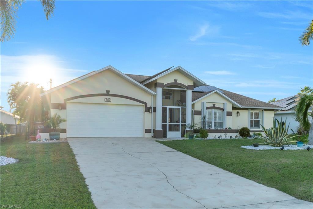 Image 2: Ranch-style home with stucco siding, driveway, and a front lawn