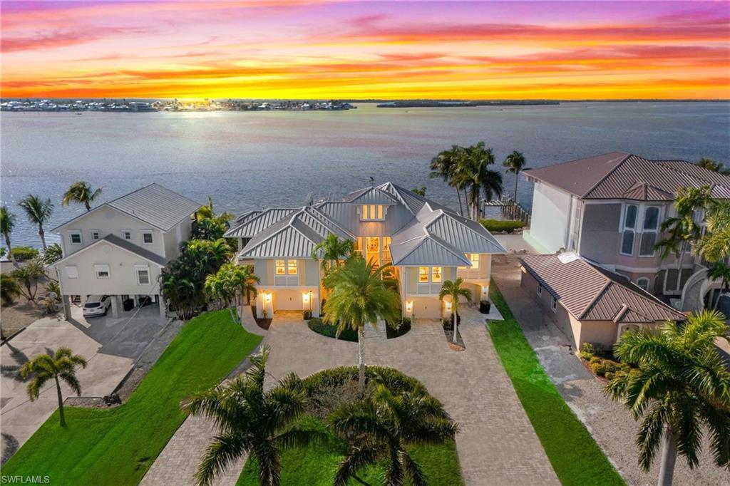 Image 3: Curb appeal alert!  Large circular paved driveway welcomes you to this STUNNING 3 bedrooms and a den, 5 bathrooms, and split 4 car garage!  Endless views of sunsets and a dream waterfront lot!