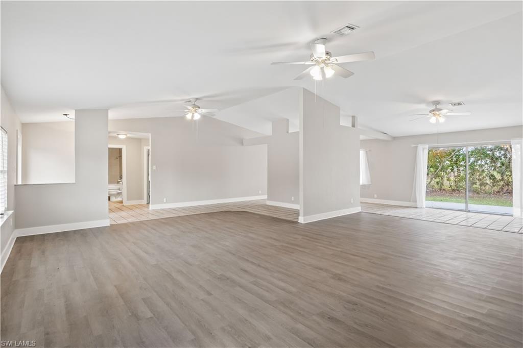 Image 4: Bright and open living space featuring soaring cathedral ceilings, abundant natural light, and a seamless flow perfect for everyday living and entertaining.