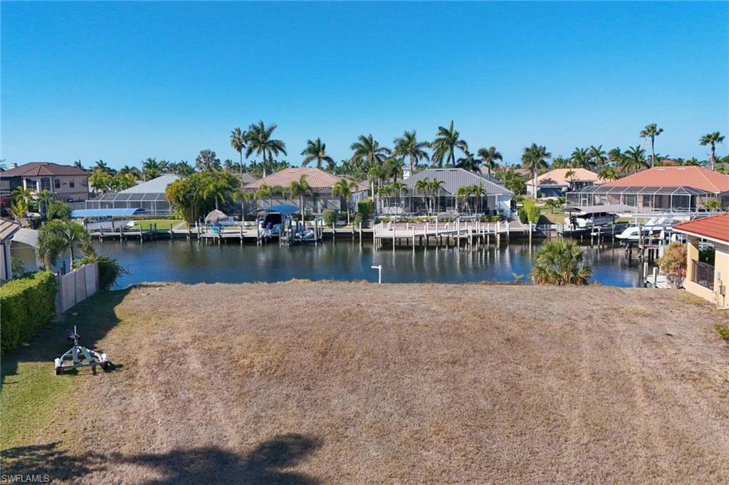 Image 4: Dock area with a residential view, a water view, and a lawn