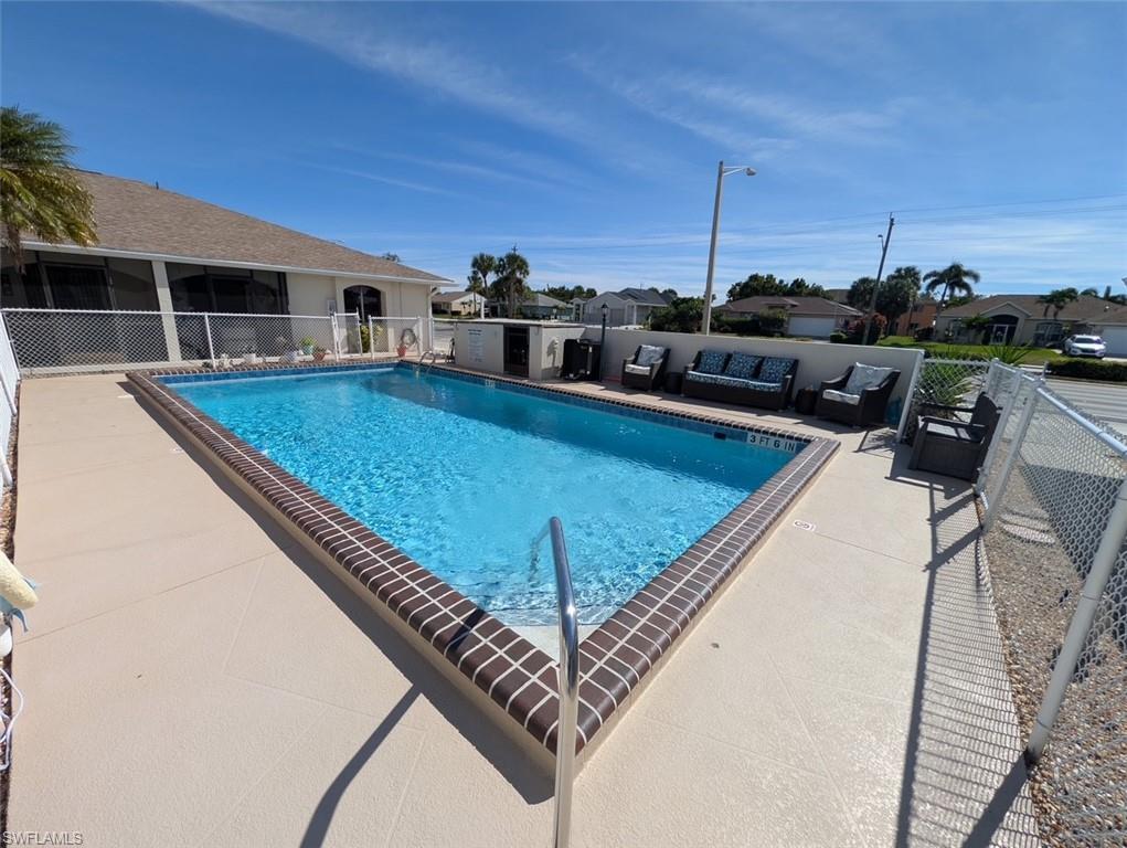 Image 4: Community pool with an outdoor living space, a patio area, a residential view, and a sunroom