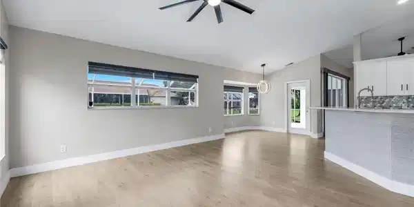 Image 2: Family Room  featuring , vaulted ceilings Luxury Vinyl Plank Flooring, and a contemporary ceiling fan