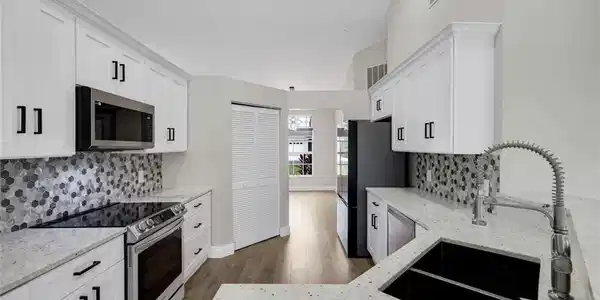 Image 3: Kitchen featuring white shaker cabinetry, speckled countertops, a mosaic tile backsplash, Samsung Stainless Steel Appliances, Quartz Countertops