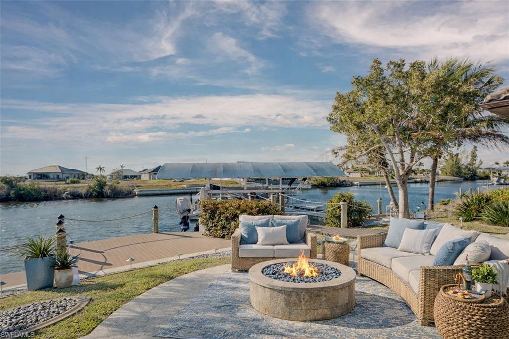 Image 2: View of patio with a fire pit, a water view, and a boat dock
