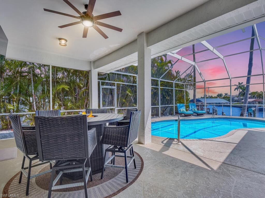 Image 4: Pool at dusk featuring a patio, a lanai, an outdoor pool, a sunroom, and outdoor dining space