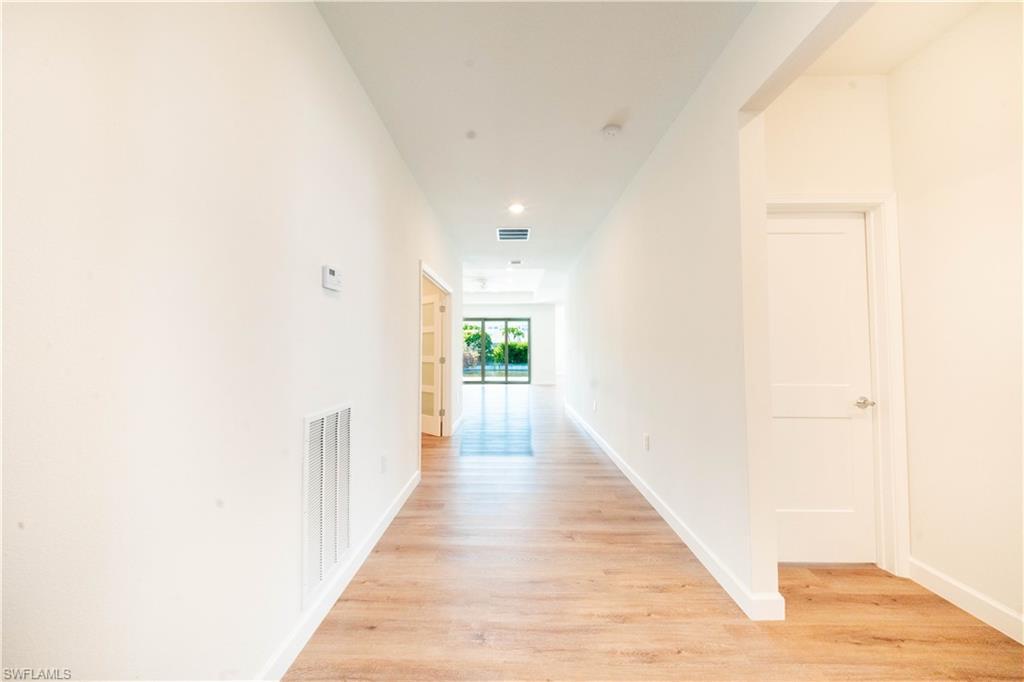 Image 3: Hallway with light wood finished floors and recessed lighting